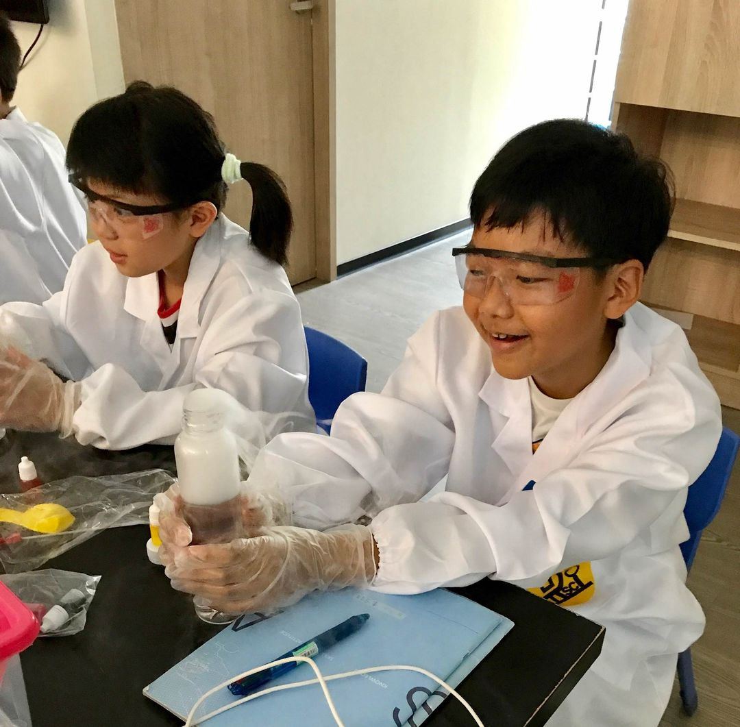 學生看著瓶中冒出的白霧露出笑容