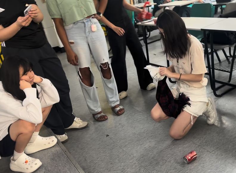 學生蹲在地上進行鋁罐挑戰